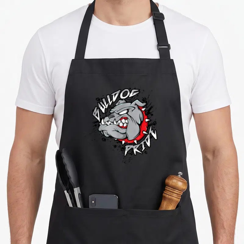 Mascot english chef aprons - Grey bulldog head red spiked collar BULLDOG PRIDE text black splatter paw prints — shown on a black cotton canvas apron against a white background