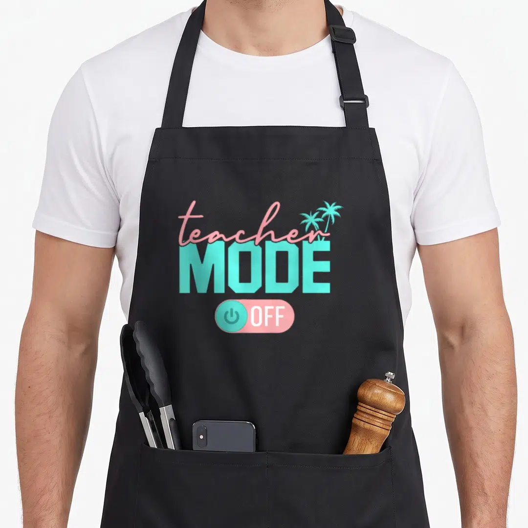 Mode teacher apron - Teacher Mode Off text with two palm trees and pink power button toggle — shown on a black cotton canvas apron against a white background