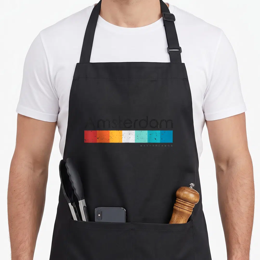 Vintage amsterdam netherlands apron - Amsterdam text above six red orange yellow white and blue rectangles — shown on a black cotton canvas apron against a white background
