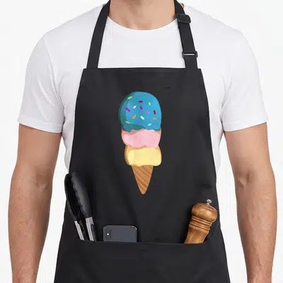 Funny cone ice cream apron - Cartoon ice cream cone with blue pink and yellow scoops topped with sprinkles — shown on a black cotton canvas apron against a white background