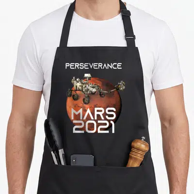 Perseverance nasa apron - Mars rover on red planet with PERSEVERANCE and MARS 2021 text in white and grey — shown on a black cotton canvas apron against a white background