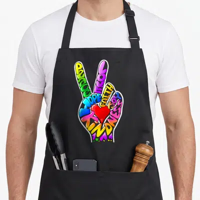 Peace faith aprons - Cartoon hand formed by words PEACE LOVE HOPE FAITH JOY KINDNESS with red heart and small hearts — shown on a black cotton canvas apron against a white background