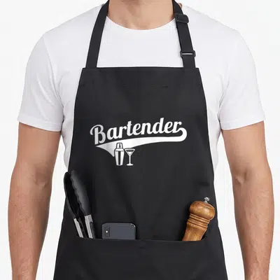 Cocktail bartender apron - White script Bartender text with shaker and martini glass icons on black background — shown on a black cotton canvas apron against a white background
