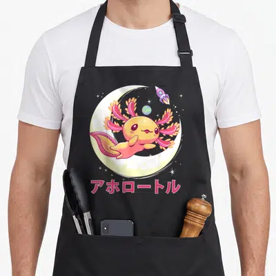 Goth axolotl anime cooking apron - Pink axolotl floating in yellow moon with rocket planet and Japanese text — shown on a black cotton canvas apron against a white background