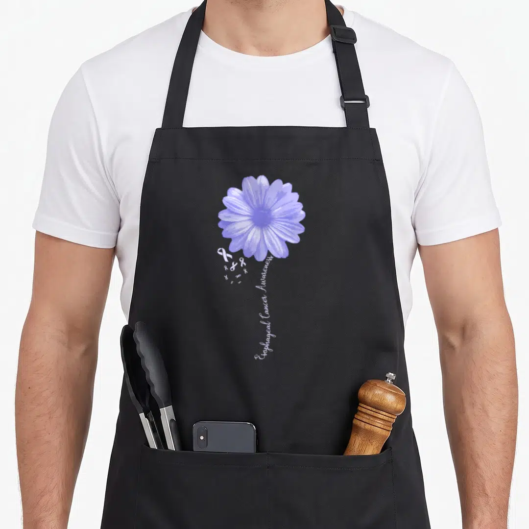 Esophageal pretty apron - Purple flower with white ribbons and vertical text reading Esophageal Cancer Awareness — shown on a black cotton canvas apron against a white background