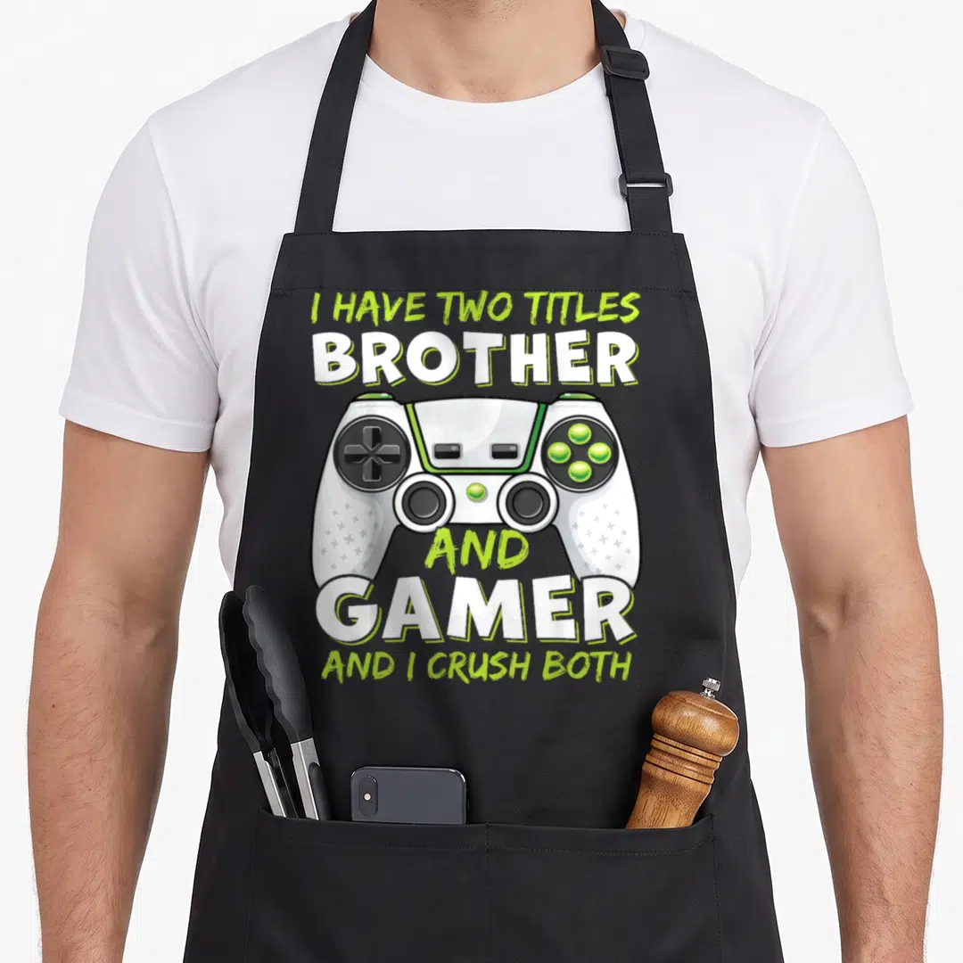 Cute gamer video game apron - White and lime green game controller with stacked text I have two titles brother and gamer — shown on a black cotton canvas apron against a white background