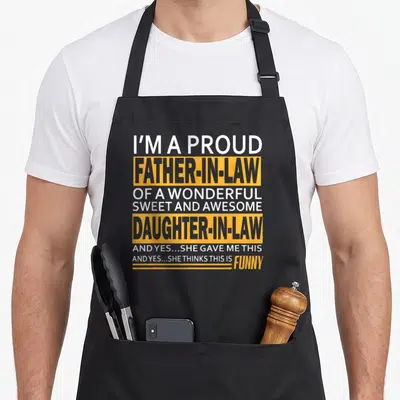Proud law father daughter aprons - Stacked white and yellow text reading I'm a proud father-in-law of a wonderful sweet — shown on a black cotton canvas apron against a white background