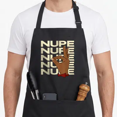 Funny fraternity alpha apron - NUPE text stack with brown OK hand and red bow tie cartoon design — shown on a black cotton canvas apron against a white background