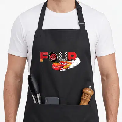 Number car apron - Lightning McQueen drifting under word FOUR with tire and checkered pattern — shown on a black cotton canvas apron against a white background