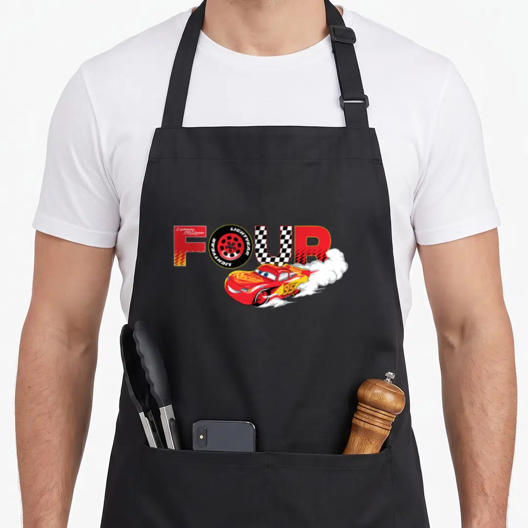 Number car apron - Lightning McQueen drifting under word FOUR with tire and checkered pattern — shown on a black cotton canvas apron against a white background