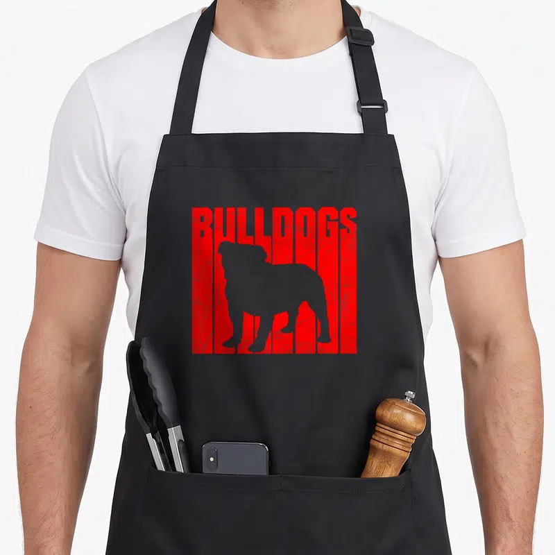 Bulldog sports team aprons - Grey bulldog silhouette over red distressed block with BULLDOGS text — shown on a black cotton canvas apron against a white background