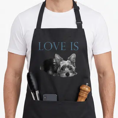 Terrier yorkshire apron - Blue-grey LOVE IS text above a black and white photo of a lying Yorkshire Terrier dog — shown on a black cotton canvas apron against a white background