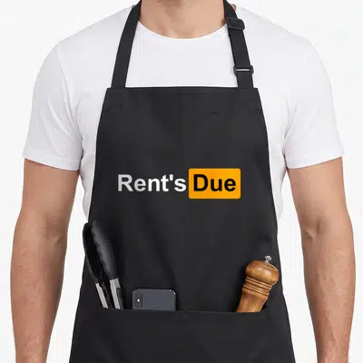 Rent roommate apron - Rent's Due text with Due inside orange rounded rectangle — shown on a black cotton canvas apron against a white background