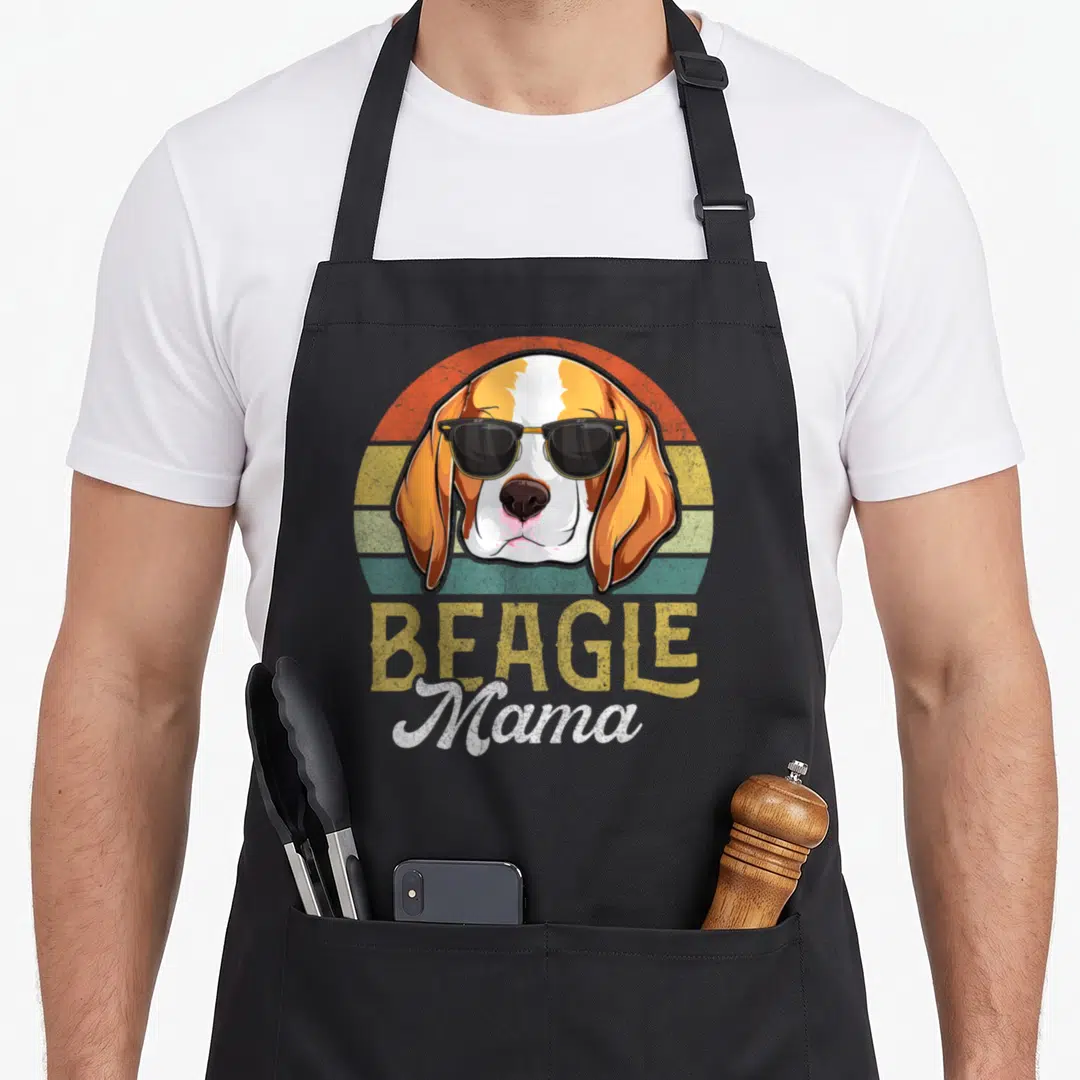 Mother beagle apron - Retro beagle head wearing sunglasses over orange and yellow sunset stripes with stacked text below — shown on a black cotton canvas apron against a white background