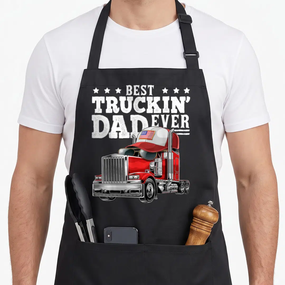 Truckin father day apron - Red semi-truck with sunglasses and Best Truckin Dad Ever text — shown on a black cotton canvas apron against a white background