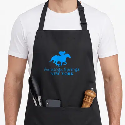 Saratoga spring apron - Blue silhouette of a horse and rider above Saratoga Springs New York text — shown on a black cotton canvas apron against a white background