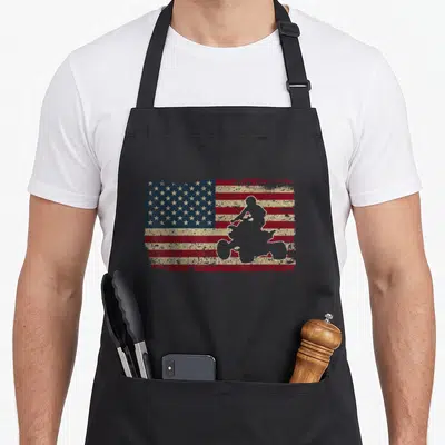 Quad bike apron - Distressed US flag with white ATV rider silhouette on right side — shown on a black cotton canvas apron against a white background