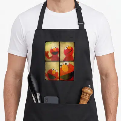 Booth elmo apron - Four photos of red character peering through window panes with yellow background — shown on a black cotton canvas apron against a white background