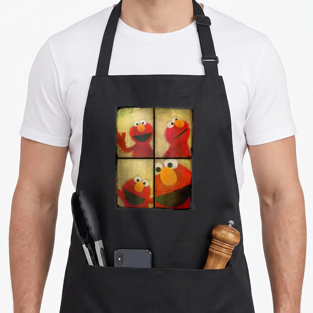 Booth elmo apron - Four photos of red character peering through window panes with yellow background — shown on a black cotton canvas apron against a white background