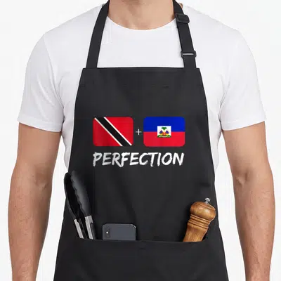 Trinidadian haitian heritage aprons - Two flags with plus sign and PERFECTION text below — shown on a black cotton canvas apron against a white background
