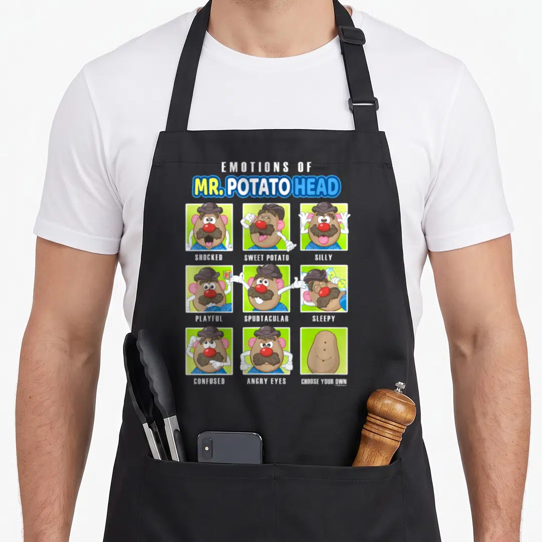 Emotion potato apron - Mr. Potato Head cartoon grid with labels SHOCKED SWEET POTATO SILLY and CHOOSE YOUR OWN — shown on a black cotton canvas apron against a white background