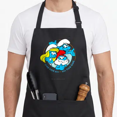 Novelty apron for chefs - Three Smurfs in blue circle with ONE FOR ALL ALL FOR ONE text — shown on a black cotton canvas apron against a white background