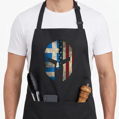 Greece greek aprons - Distressed spartan helmet filled with blue white and red flag patterns split vertically — shown on a black cotton canvas apron against a white background