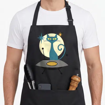 Ufo modern apron - Blue cat in grey flying saucer with yellow moon and three stars in retro cartoon style — shown on a black cotton canvas apron against a white background