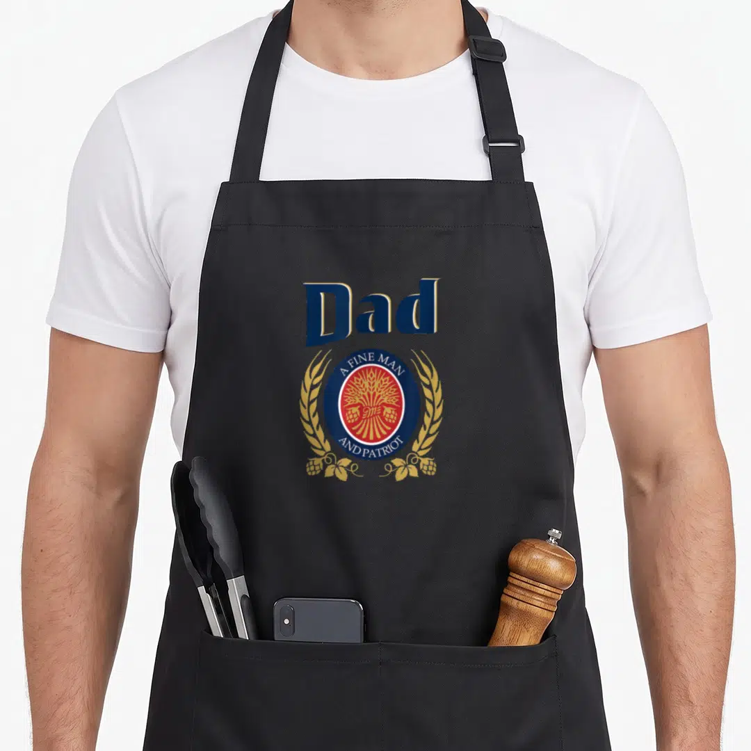 Miller father day apron - Dad A Fine Man Patriot emblem with hops wheat blue red gold — shown on a black cotton canvas apron against a white background