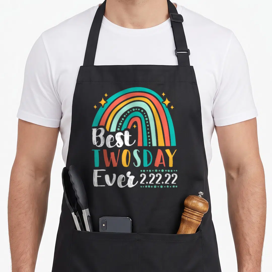 Twosday rainbow apron - Rainbow arch over Best TWOSDAY Ever 2.22.22 text in teal orange yellow red white — shown on a black cotton canvas apron against a white background