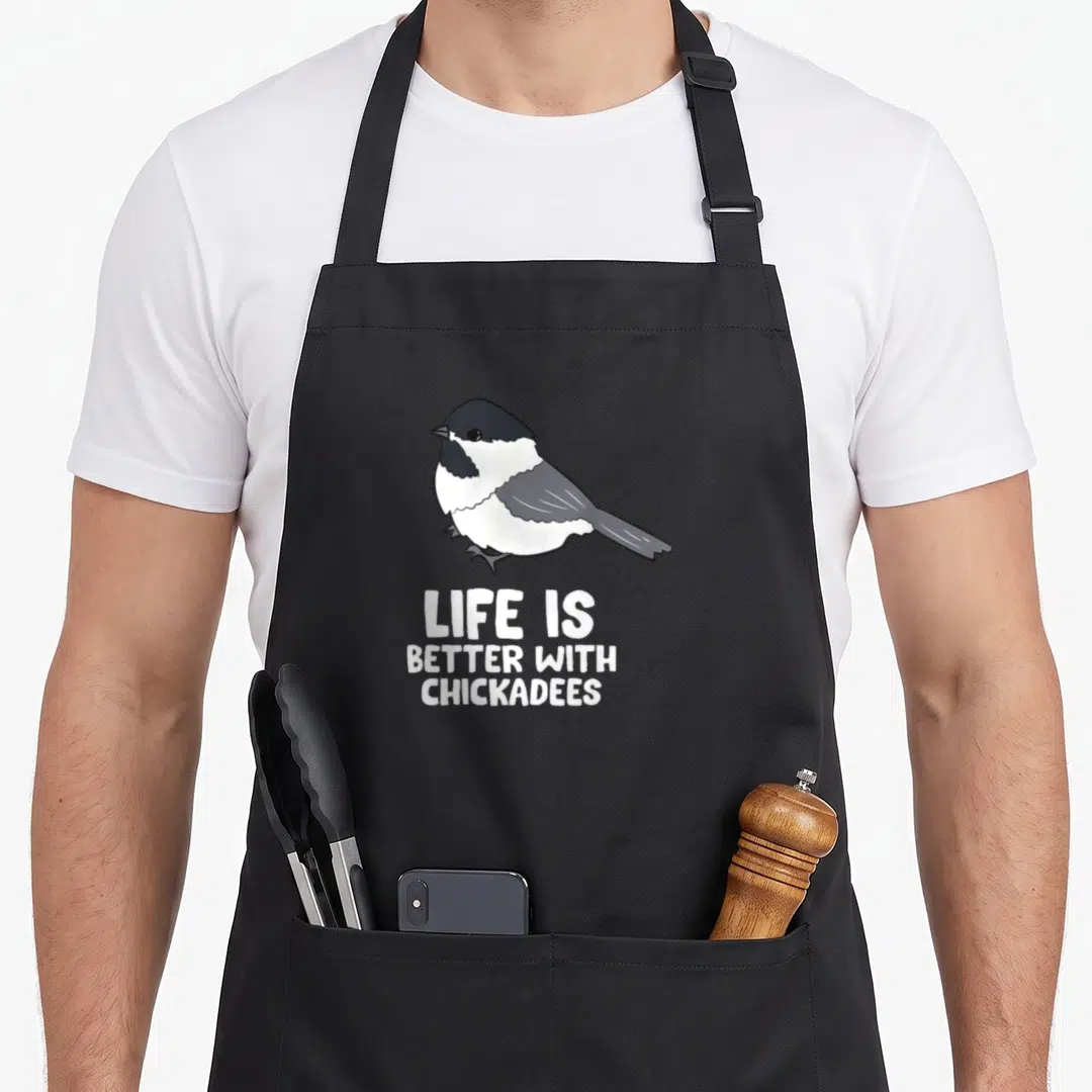 Chickadee bird aprons - Cartoon black capped chickadee above white text reading Life Is Better With Chickadees — shown on a black cotton canvas apron against a white background