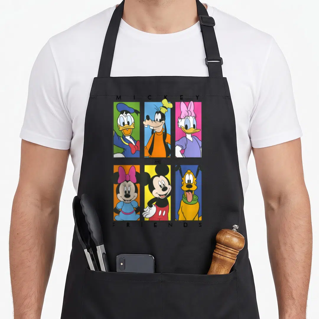 Shot friends cooking apron - Six cartoon characters in red, blue, yellow, pink, and green vertical bars with centered — shown on a black cotton canvas apron against a white background