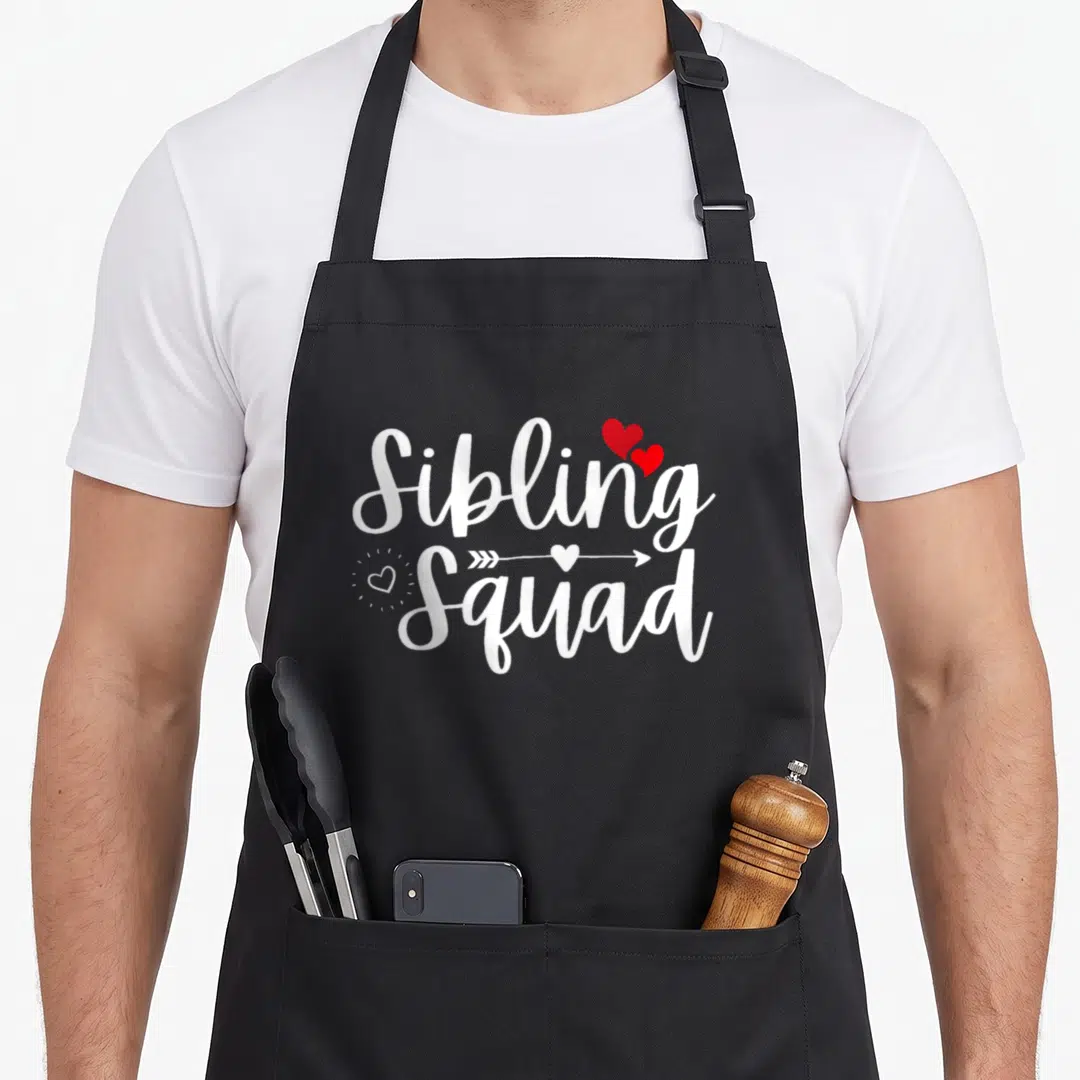 Sibling squad family aprons - White Sibling Squad text with red hearts and arrow on grey background — shown on a black cotton canvas apron against a white background