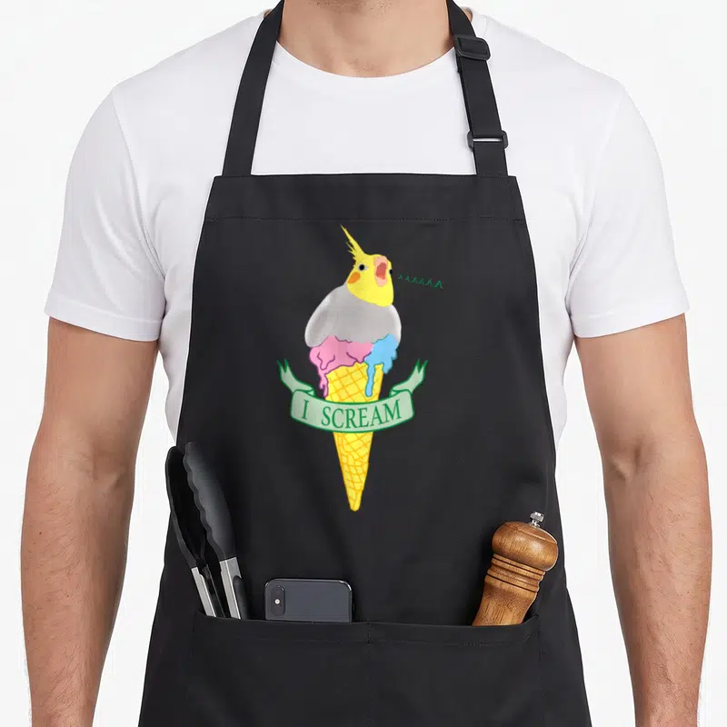 Scream ice cream apron - Cartoon cockatiel head on melting pink and blue ice cream cone with I SCREAM ribbon — shown on a black cotton canvas apron against a white background