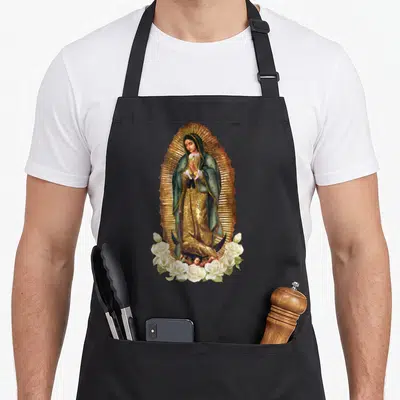 Saint catholic apron - Realistic Virgin Mary in gold halo with white roses and green robe — shown on a black cotton canvas apron against a white background