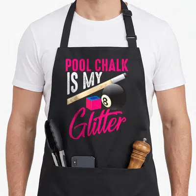 Chalk game aprons - Pool Chalk is My Glitter text with cue, 8-ball, and pink chalk cube — shown on a black cotton canvas apron against a white background