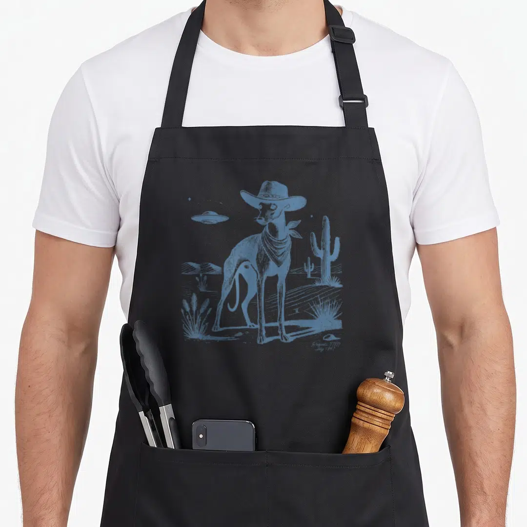 Whippet italian apron - Blue line art of a dog in a hat and bandana with a UFO and cactus — shown on a black cotton canvas apron against a white background
