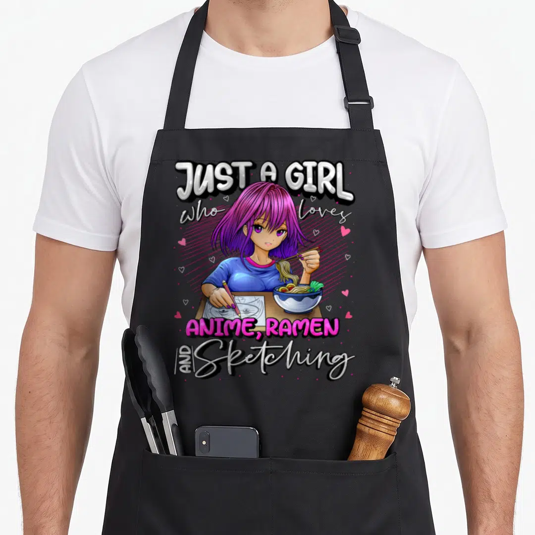 Cute anime japan apron - Girl with purple hair eating ramen and sketching with stacked text and hearts — shown on a black cotton canvas apron against a white background
