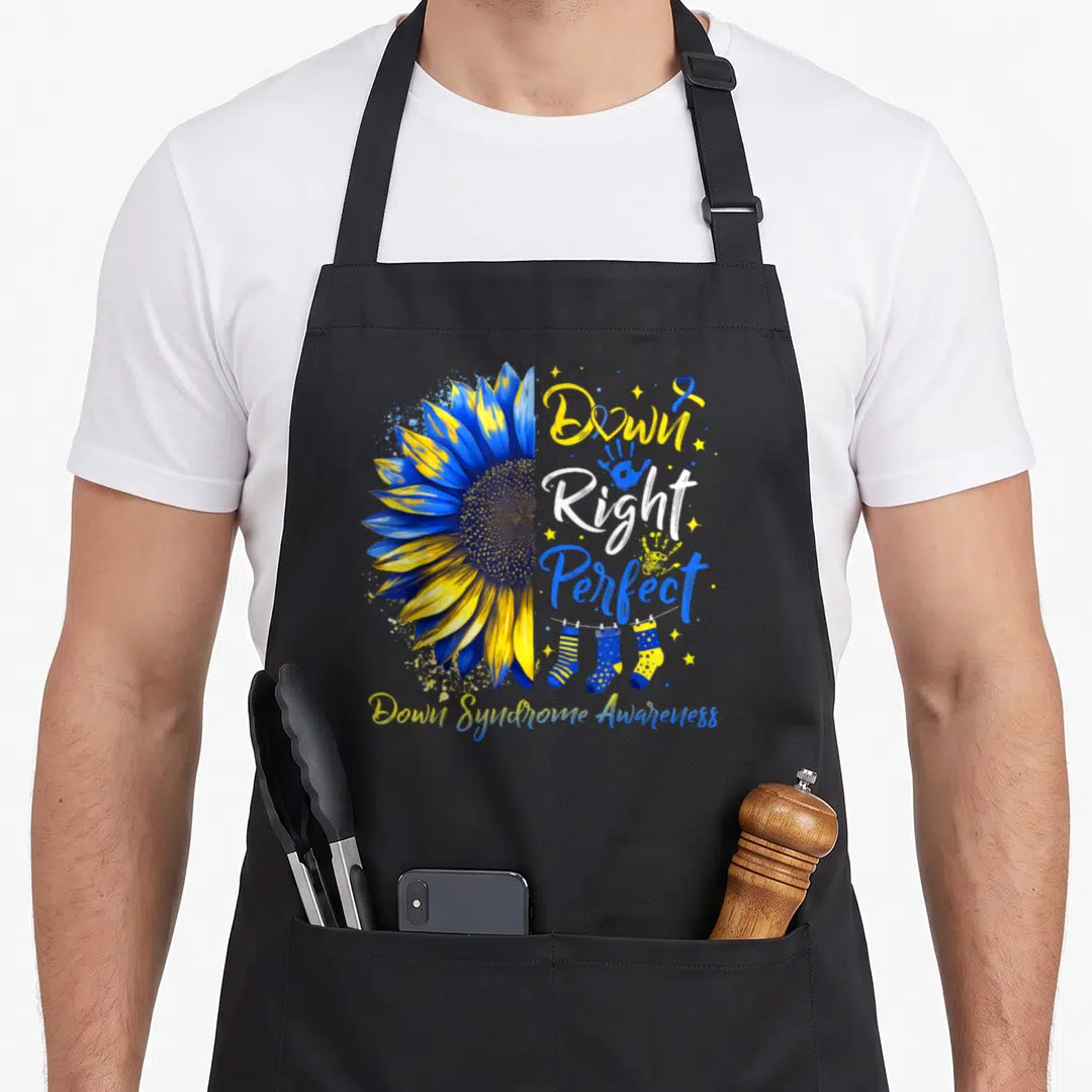 Right sunflower apron - Blue yellow sunflower with Down Right Perfect text and socks on line — shown on a black cotton canvas apron against a white background