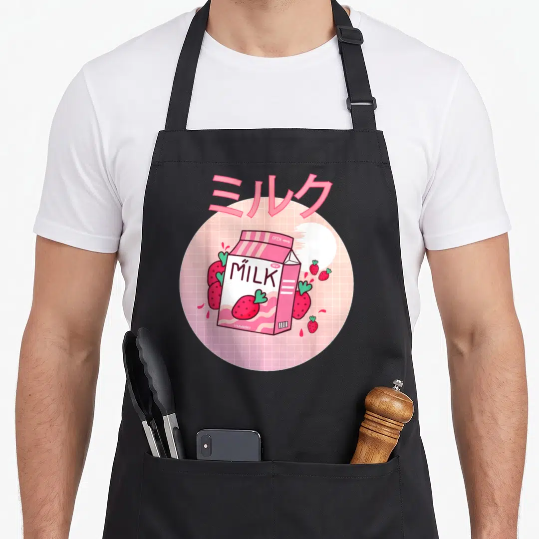 Shake milk aprons - Pink milk carton with strawberries and Japanese text on grid background — shown on a black cotton canvas apron against a white background
