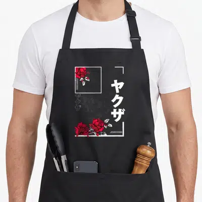 Vaporwave urban apron - Grey skull, red roses, vertical Yakuza text, white L-shaped frame corners — shown on a black cotton canvas apron against a white background