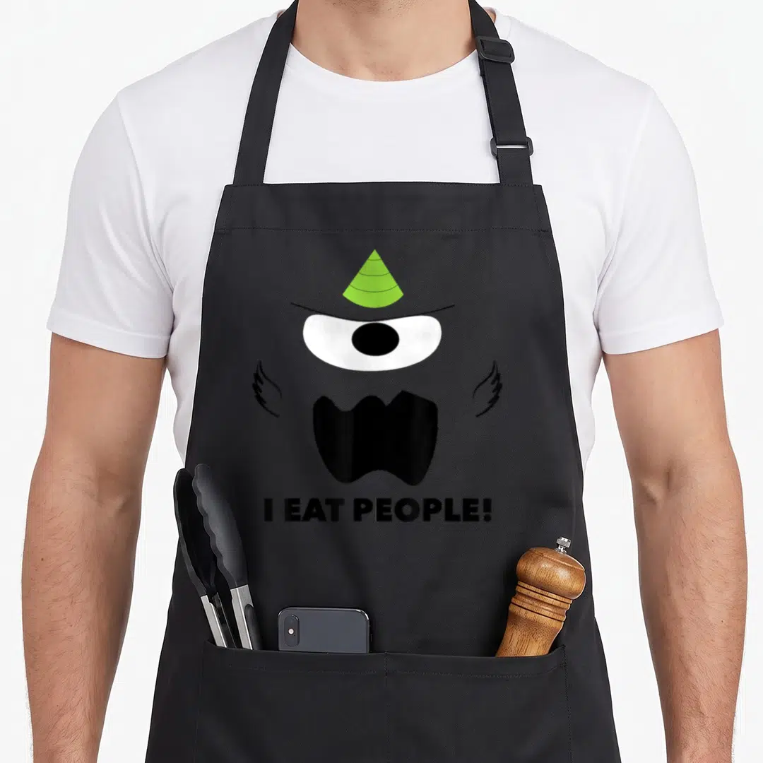 Eyed simple apron - Cartoon monster face with single eye, lime hat, wings, and text I eat people — shown on a black cotton canvas apron against a white background