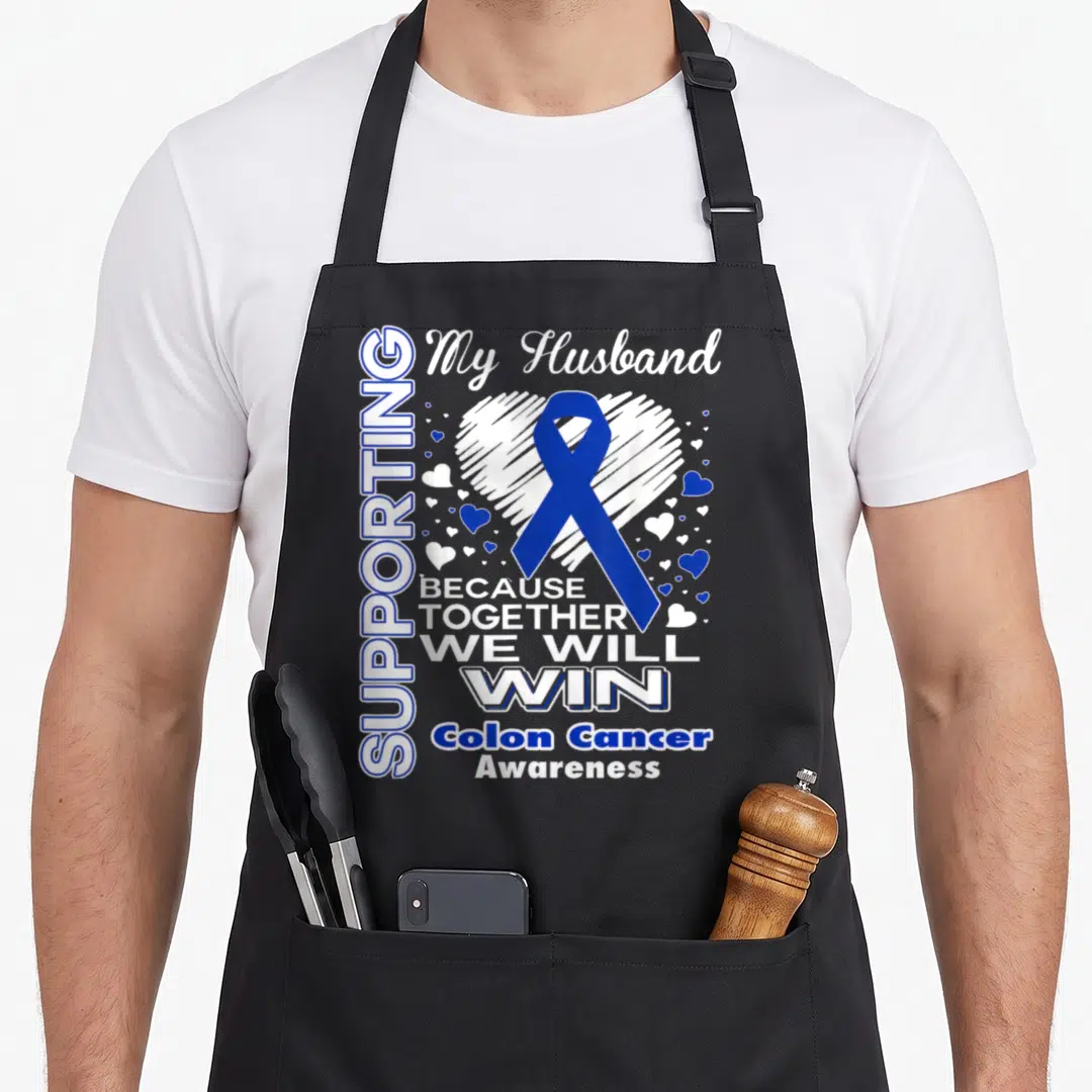 Colon husband apron - Blue ribbon over white heart with text supporting my husband colon cancer awareness — shown on a black cotton canvas apron against a white background