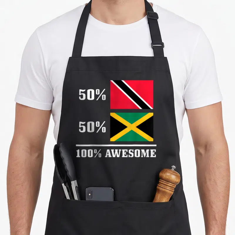 Jamaica trinidadian apron - Two stacked flags with 50% 50% 100% AWESOME text in red green yellow black white — shown on a black cotton canvas apron against a white background