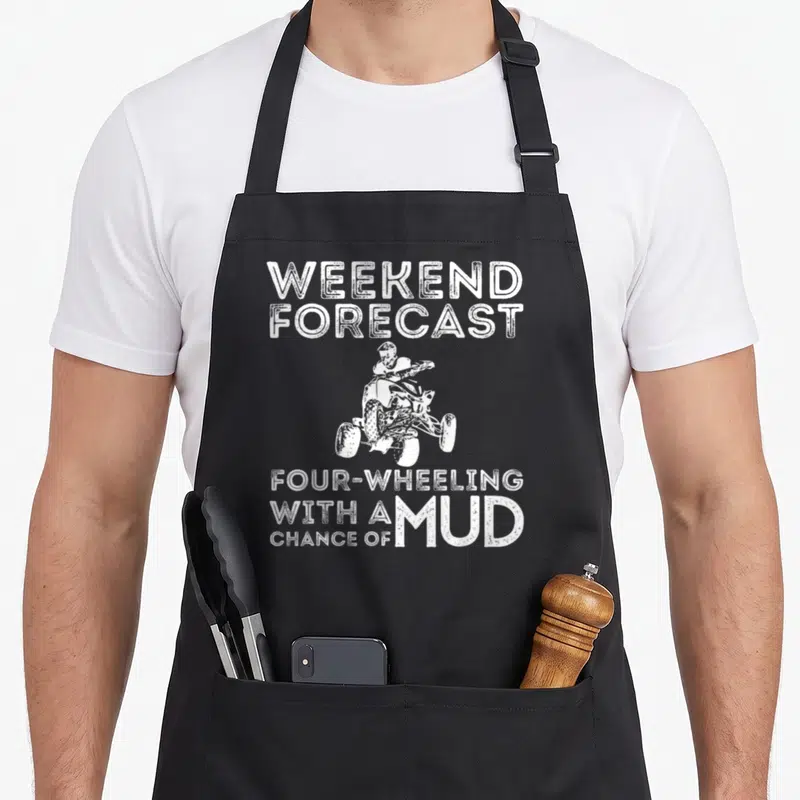 Forecast atv apron - White distressed text weekend forecast four wheeling chance of mud around ATV rider illustration — shown on a black cotton canvas apron against a white background