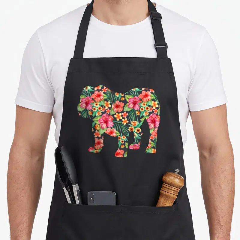 Silhouette english chef aprons - Elephant silhouette filled with red pink green and orange tropical flowers — shown on a black cotton canvas apron against a white background