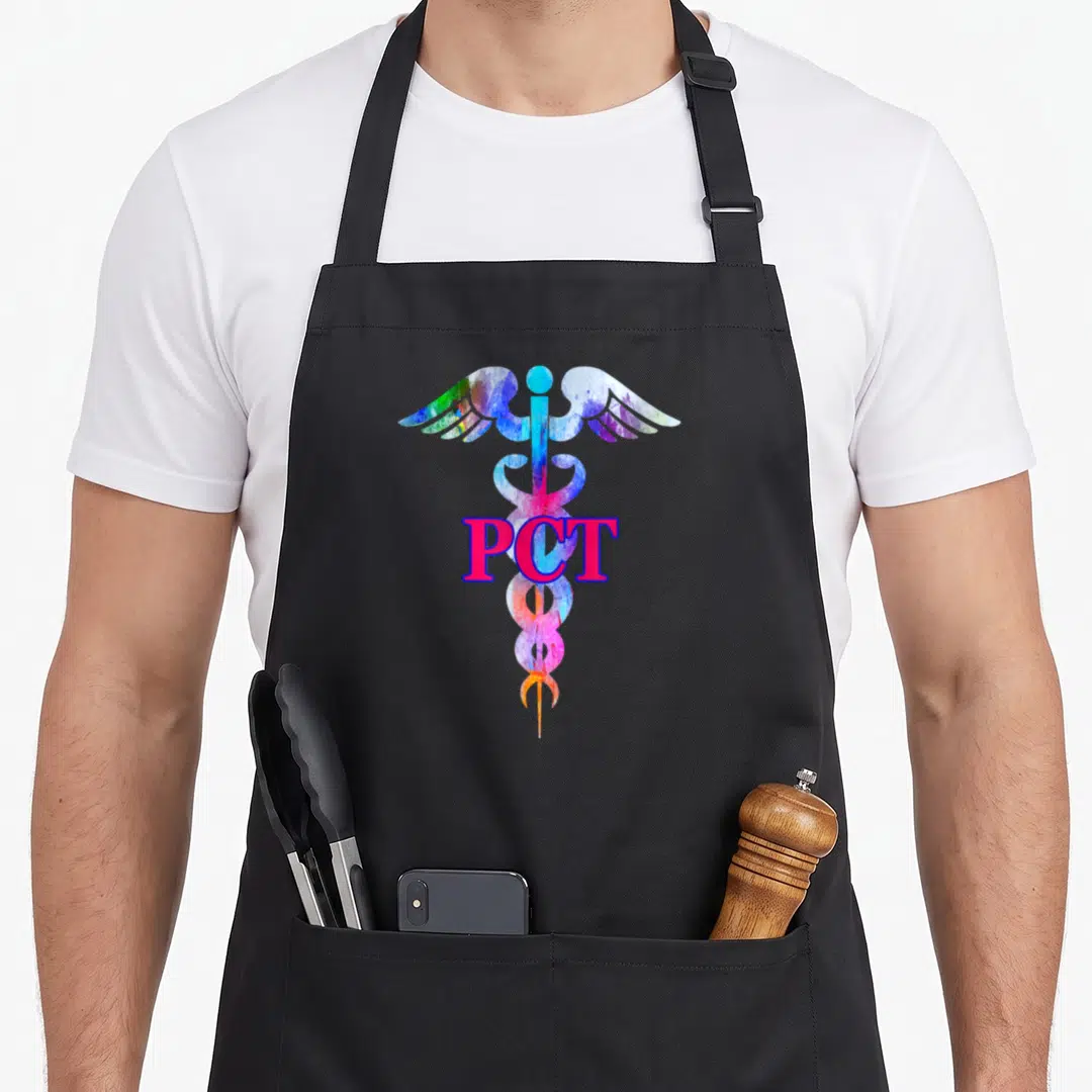 Care patient apron - PCT text over multicolored watercolor caduceus with pink blue green yellow purple hues — shown on a black cotton canvas apron against a white background