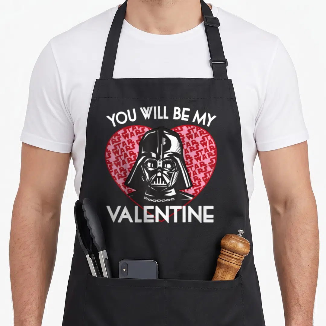 Vader valentine's day apron - Darth Vader head inside red heart with You Will Be My Valentine text — shown on a black cotton canvas apron against a white background