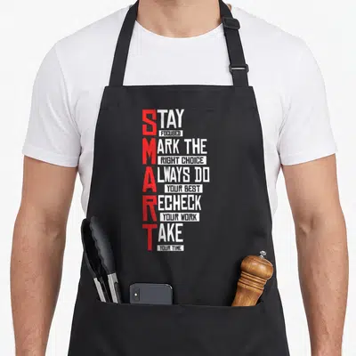 Exam teacher apron - SMART acronym in red with white stacked text advice phrases — shown on a black cotton canvas apron against a white background