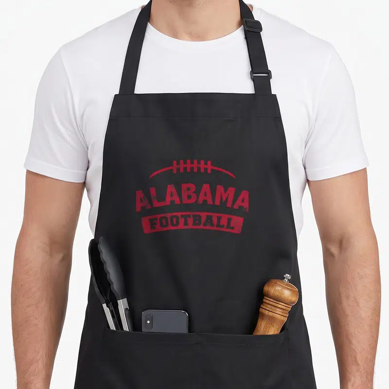 Distressed alabama apron - Red distressed football graphic with arched ALABAMA FOOTBALL text — shown on a black cotton canvas apron against a white background
